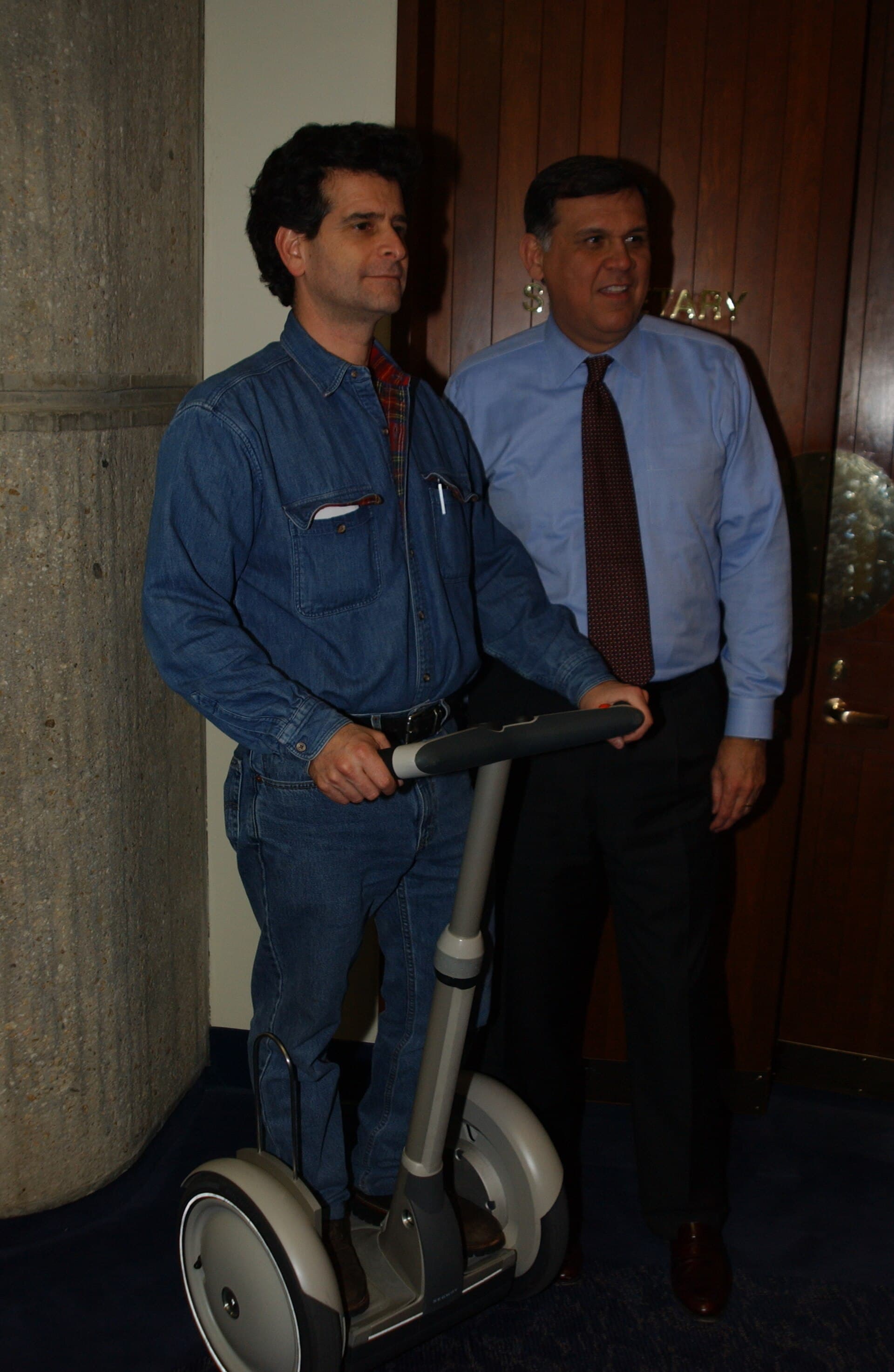 Dean Kamen on an early Segway beside HUD Secretary Mel Martinez.